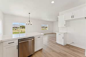 Kitchen with stainless steel dishwasher, light countertops, light wood finished floors, recessed lighting, and white cabinetry