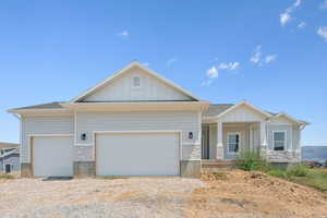Craftsman-style home featuring stone siding, board and batten siding, driveway, and a garage