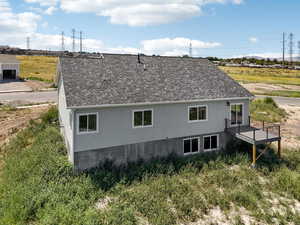 Rear view of house with roof with shingles and stucco siding