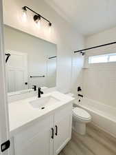 Bathroom with shower / bathtub combination, vanity, and light wood-type flooring