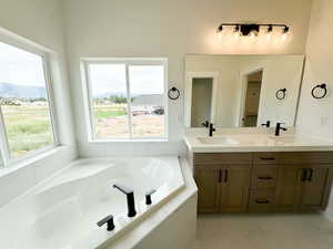 Full bath featuring double vanity, a bath, and a closet
