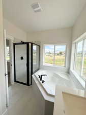 Bathroom with a shower stall, a garden tub, and light marble finish flooring