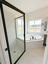 Full bath with a garden tub, vanity, a stall shower, and tile patterned floors