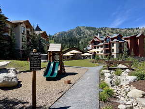 Community play area featuring a mountain view and a lawn