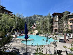 Community pool featuring a mountain view, a patio area, and a water slide