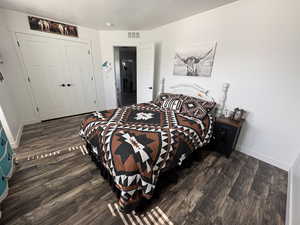 Bedroom with wood finished floors and a closet