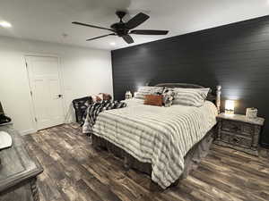 Bedroom featuring wood finished floors, wooden walls, recessed lighting, and a ceiling fan