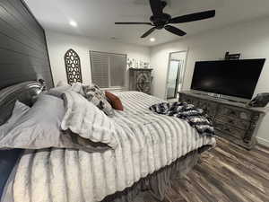 Bedroom with wood finished floors, recessed lighting, ceiling fan, and wood walls