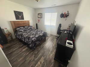 Bedroom with dark wood-style floors and baseboards