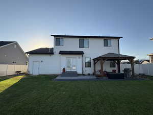 Back of property at dusk featuring a gazebo, a fenced backyard, a patio, and entry steps