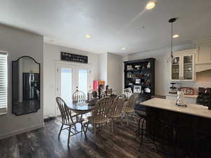 Dining area with dark wood-style flooring, recessed lighting, and french doors
