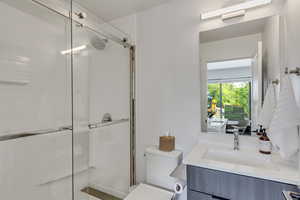 Full bath with a shower stall and vanity