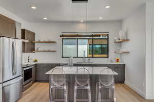 Kitchen with open shelves, modern cabinets, appliances with stainless steel finishes, a kitchen breakfast bar, and recessed lighting
