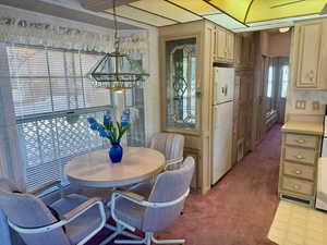 Dining area with light carpet and a chandelier