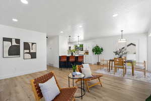 Living area featuring recessed lighting, light wood finished floors, and a textured ceiling