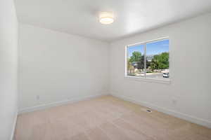Unfurnished room with light carpet and baseboards