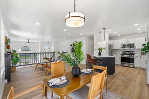 Dining room with a ceiling fan, light wood finished floors, and recessed lighting