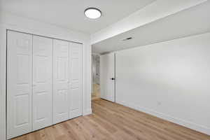 Unfurnished bedroom featuring light wood finished floors and a closet