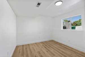 Empty room featuring baseboards and light wood finished floors