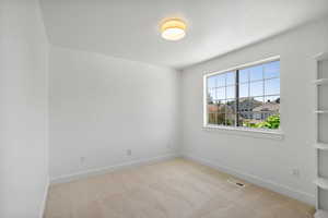 Carpeted spare room featuring baseboards