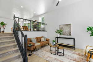 Living room featuring wood finished floors, a ceiling fan, stairway, and recessed lighting
