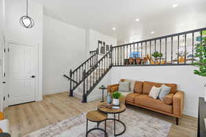 Living area with wood finished floors, recessed lighting, and stairway