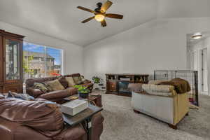 Living room featuring vaulted ceiling, carpet floors, and ceiling fan
