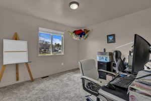 Carpeted home office featuring baseboards
