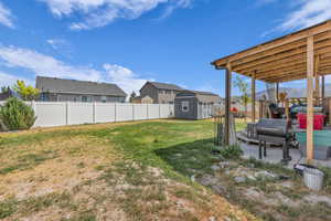 Fenced backyard featuring a shed and a residential view