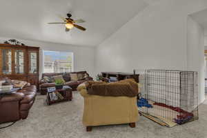 Living room with vaulted ceiling, carpet floors, and ceiling fan