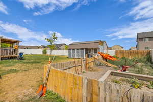 View of front of home featuring a storage unit, a fenced backyard, a residential view, a vegetable garden, and a deck