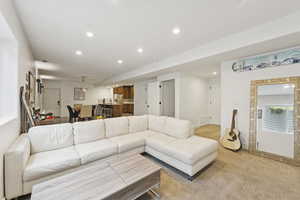 Living area with recessed lighting and light colored carpet