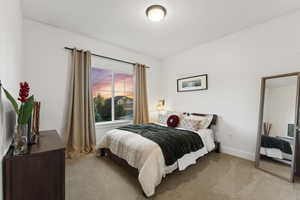 Bedroom with light colored carpet and baseboards