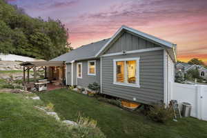 Back of property at dusk with board and batten siding and roof with shingles