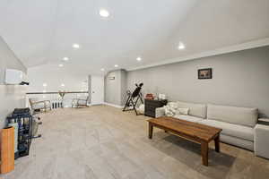 Living area featuring lofted ceiling, a textured ceiling, light colored carpet, and recessed lighting