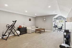Living area with light colored carpet, lofted ceiling, recessed lighting, and a textured ceiling
