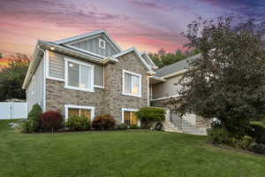View of front of property featuring board and batten siding, brick siding, and a gate