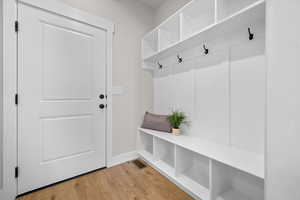 Mudroom with light wood-style floors and baseboards