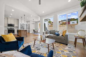 Living room featuring recessed lighting, lofted ceiling, dark wood-type flooring, and a chandelier