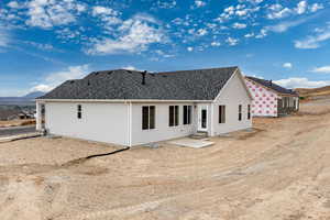 Back of property featuring a patio area, entry steps, a mountain view, and a shingled roof