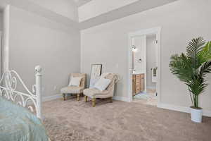 Bedroom featuring light carpet and ensuite bath