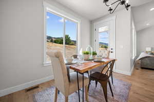 Dining space featuring plenty of natural light, light wood-style floors, and a chandelier
