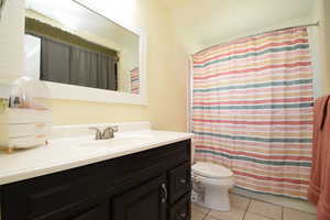 Bathroom featuring vanity, tile patterned floors, and curtained shower