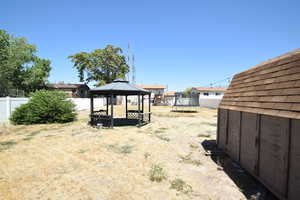 Fenced yard with a trampoline and a gazebo