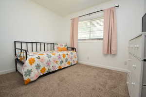 Carpeted bedroom featuring crown molding and baseboards