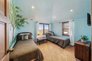 Bedroom with light colored carpet, lofted ceiling, and recessed lighting