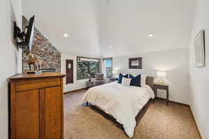 Bedroom featuring carpet and high vaulted ceiling