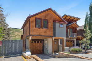 View of front of home featuring a garage, a balcony, and driveway
