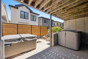 View of patio with a hot tub and a residential view