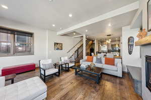 Living area featuring recessed lighting, stairs, hardwood / wood-style flooring, a fireplace, and a chandelier